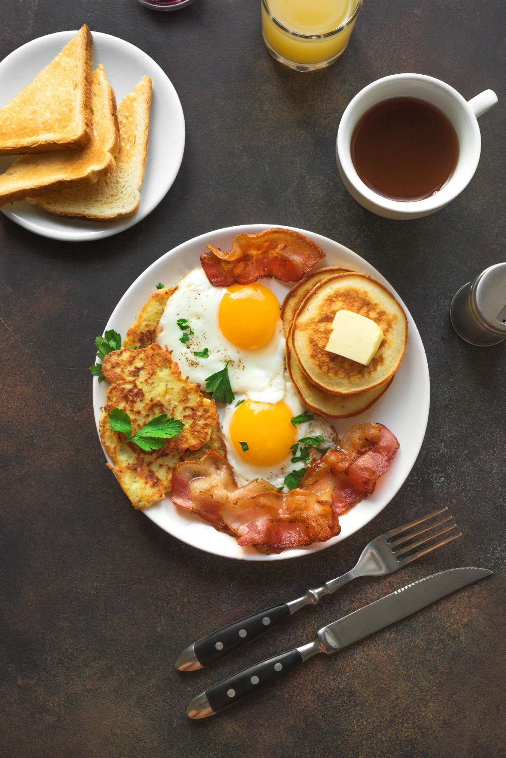 Breakfast table with my favorite eggs and fried bacon and pancakes and toast and specialty grade coffee tastiest coffee orange juice good coffee