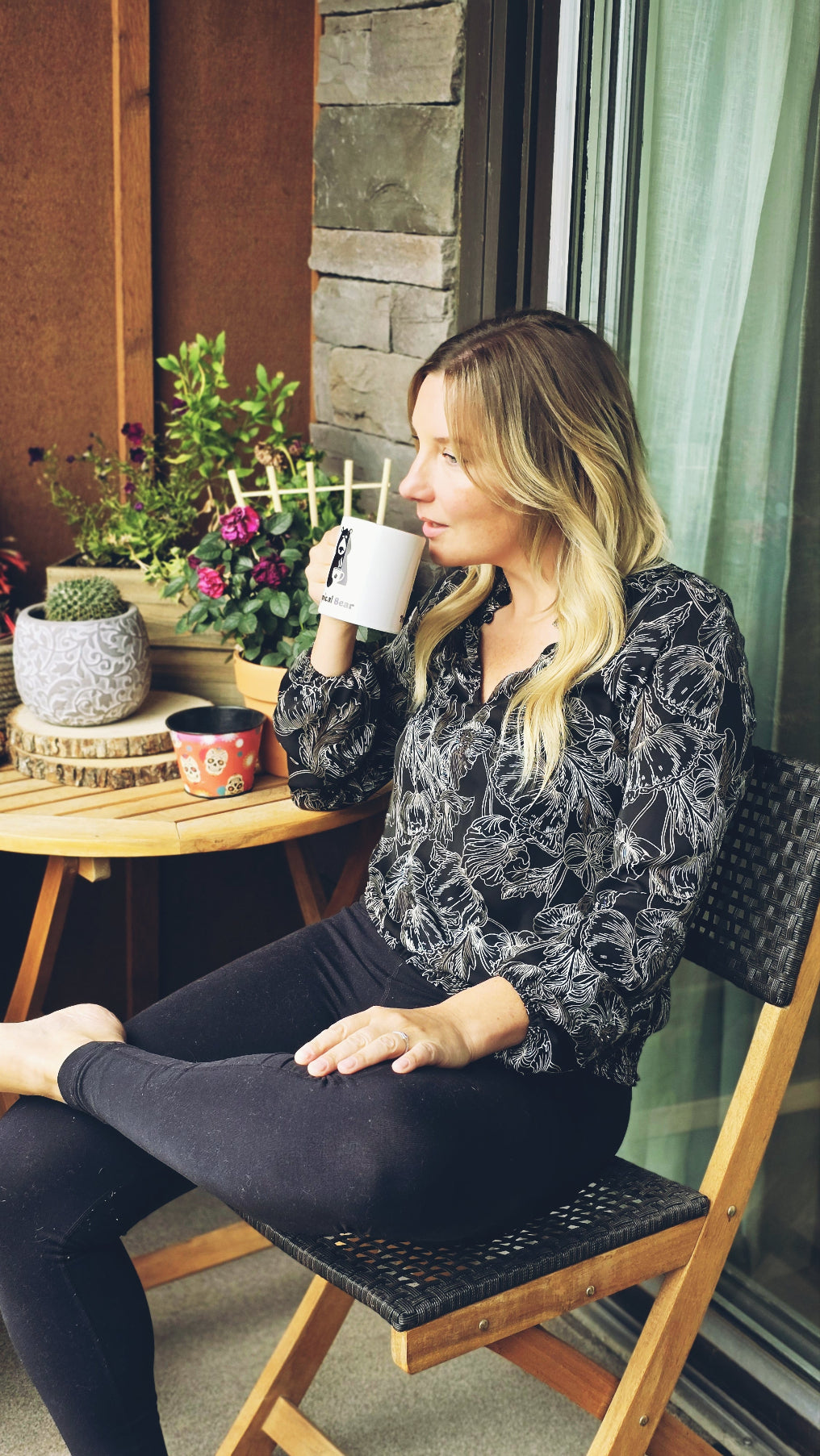 Monica sipping a cup of single-origin coffee from Ethiopia sitting on her balcony with a melancholic look.
