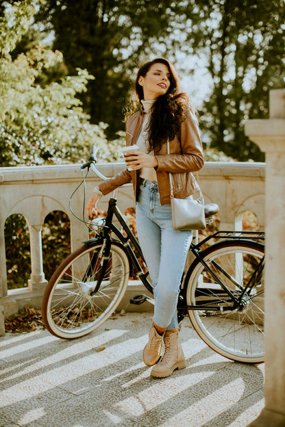 Woman with a bicycle and coffee cup in an outdoor setting