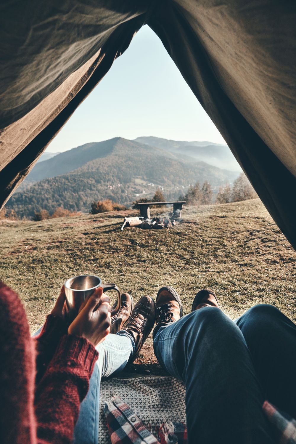 Two people in a tent drinking Elevation Kick coffee and looking at a mountain.