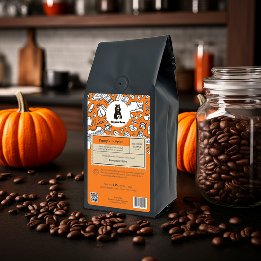 A bag of Pumpkin Spice Specialty Coffee Blend on a kitchen counter surrounded by coffee beans and pumpkins.