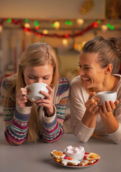 Ladies smiling at each other while drinking a cup of Tropical Bear Santa's Favorite Blend Specialty Coffee. Good coffee.