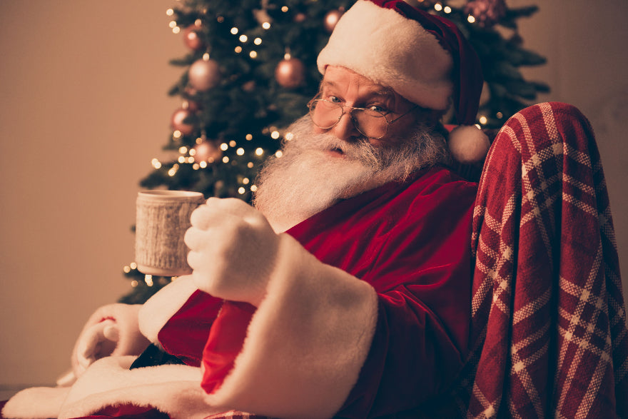 Santa holding a cup of Tropical Bear Santa's Favorite Blend Specialty Grade Coffee, dark roast. Most popular coffee flavors.