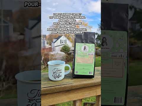 A bag of Dubai Chocolate Dreams Specialty Coffee and a coffee mug on a fence.
